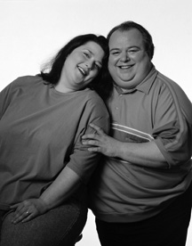 photo of middle-aged large man and large woman smiling
