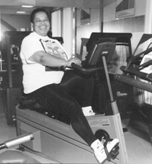 photo of large woman peddling a stationary bicycle